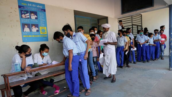 Очередь на вакцинацию от COVID-19 в школе в Ахмедабаде, Индия