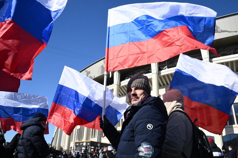 Люди у большой спортивной арены Лужники в Москве перед началом митинга-концерта, посвященного воссоединению Крыма с Россией