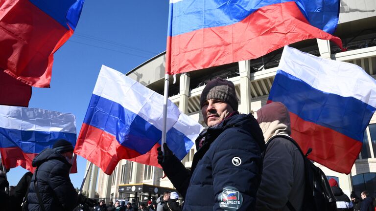 Люди у большой спортивной арены Лужники в Москве перед началом митинга-концерта, посвященного воссоединению Крыма с Россией