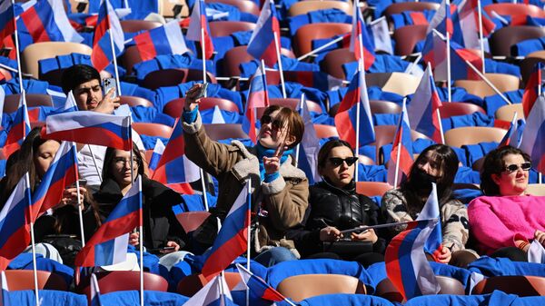 Люди собираются на трибунах стадиона Лужники на митинг-концерт, посвященный воссоединению Крыма с Россией