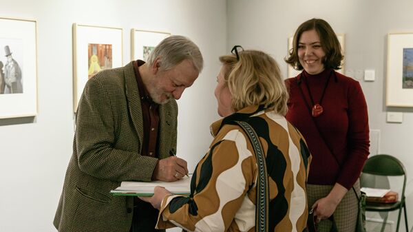 Игорь Олейников дает автограф на открытии выставки