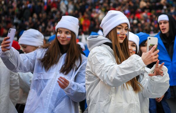 Девушки фотографируются на стадионе Лужники перед началом митинга-концерта, посвященного воссоединению Крыма с Россией