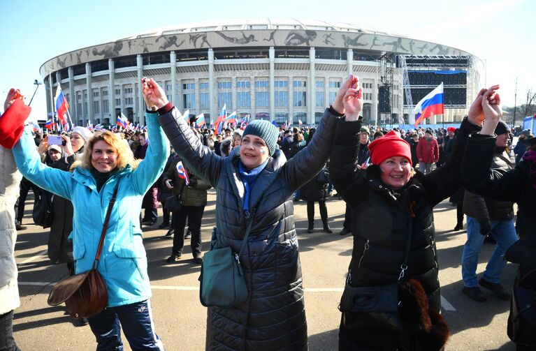 Люди собираются у большой спортивной арены Лужники в Москве перед началом митинга-концерта, посвященного воссоединению Крыма с Россией