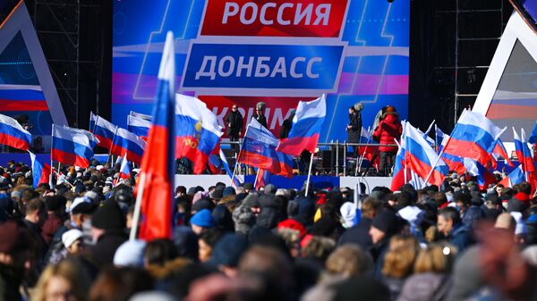 Люди собираются у большой спортивной арены Лужники в Москве перед началом митинга-концерта, посвященного воссоединению Крыма с Россией