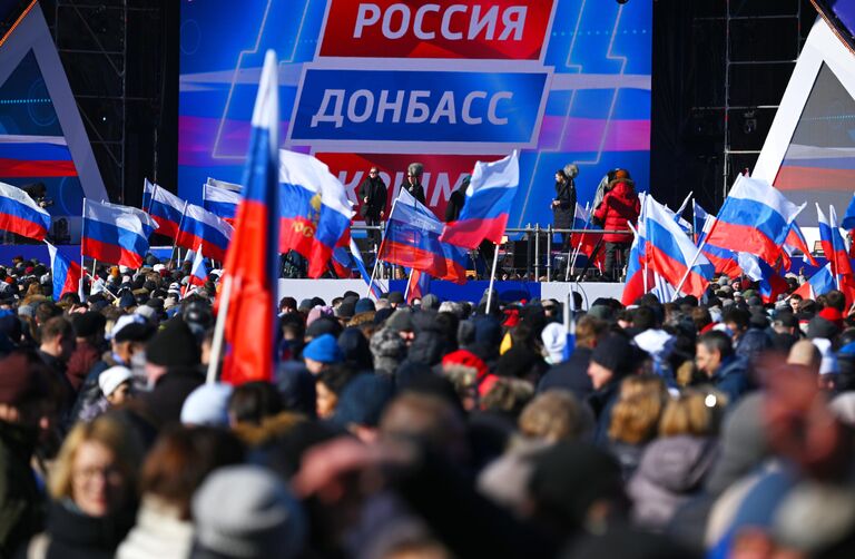 Люди собираются у большой спортивной арены Лужники в Москве перед началом митинга-концерта, посвященного воссоединению Крыма с Россией