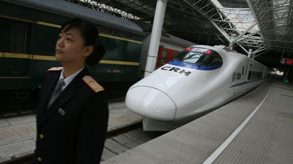 Сотрудник железной дороги рядом со сверхскоростным пассажирским экспрессом, Шанхай 