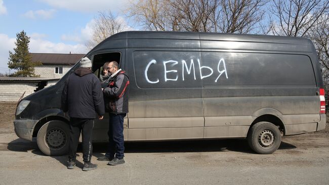 Жители покидают Мариуполь на машине с надписью Семья