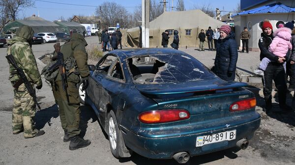 Бойцы Народной милиции ДНР осматривают машину, на которой приехали беженцы  в село Безыменное в ДНР