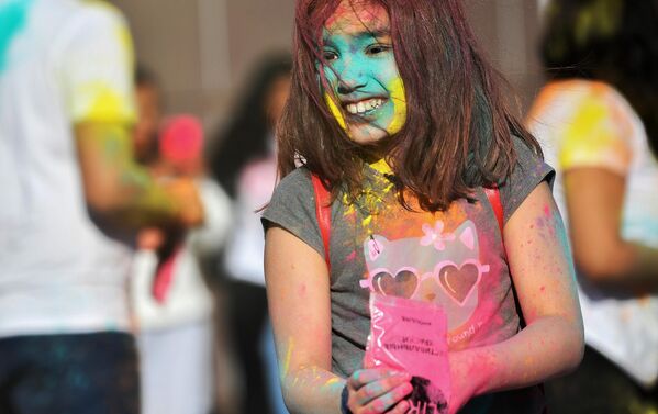  Посетительница, обсыпанная разноцветными красками на фестивале индийской культуры Холи Мела в Москве