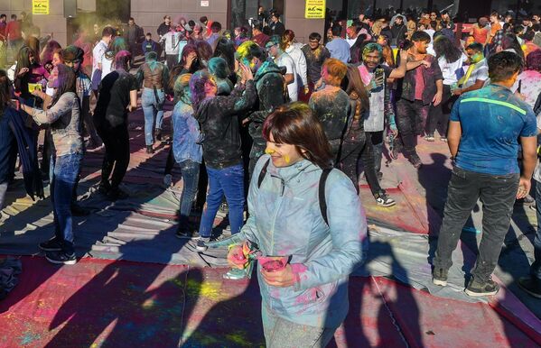 Посетители обсыпают друг друга разноцветными красками на фестивале индийской культуры Холи Мела в Москве