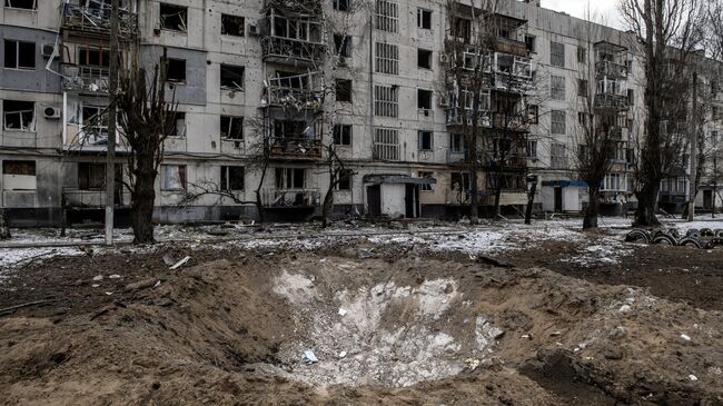 Воронка от снаряда на одной из улиц в городе Рубежное Луганской народной республики