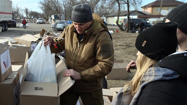 Жители Мариуполя получают у бойцов Народной милиции ДНР гуманитарную помощь, доставленную из России