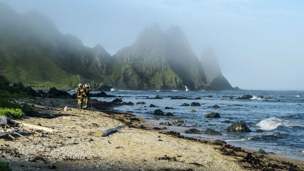 Участники экспедиции стоят на берегу мыса Васин острова Уруп