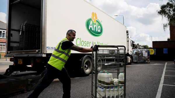 Сотрудник компании Arla Foods во время доставки продуктов в супермаркет в Лондоне 
