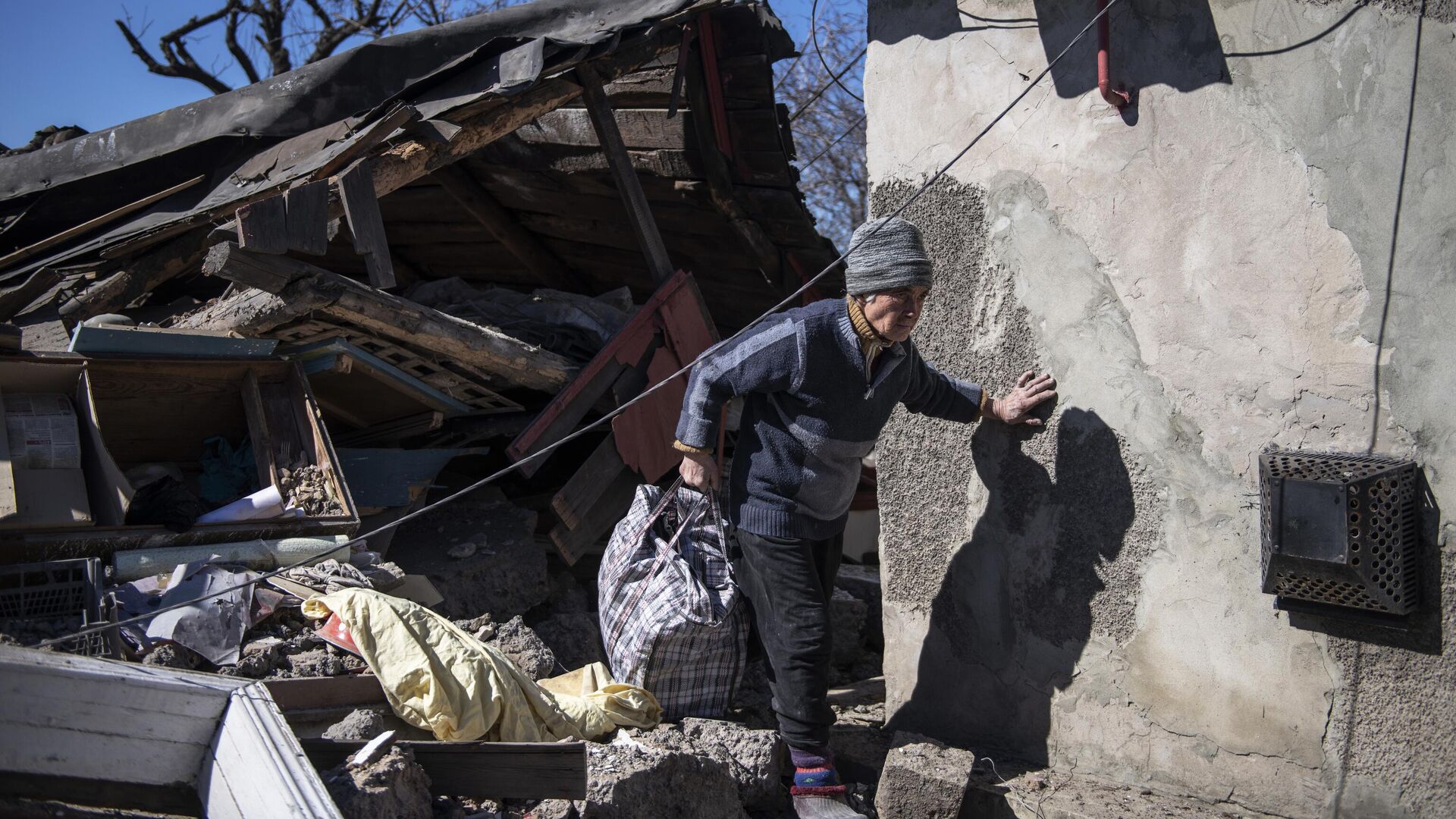 Женщина во дворе своего дома, пострадавшего в результате обстрела, в городе Брянка - РИА Новости, 1920, 15.04.2022