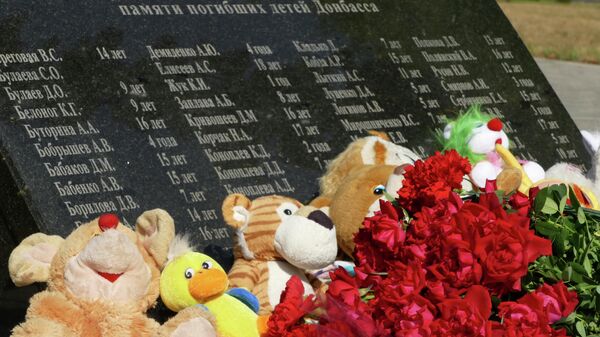 Цветы и игрушки, возложенные к памятнику Аллея Ангелов в парке Победы Калининского района Донецка