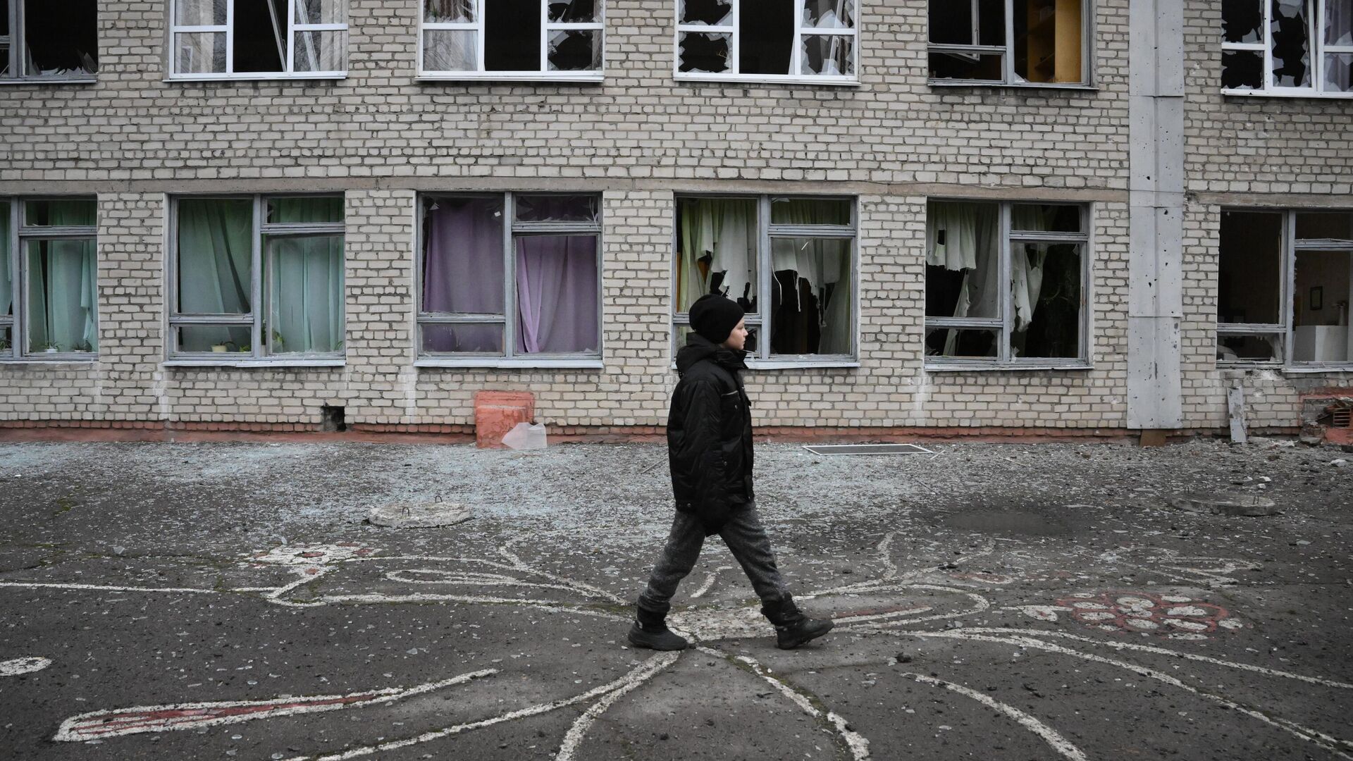 Подросток у здания школы в Горловке, поврежденного в результате обстрела - РИА Новости, 1920, 05.04.2022