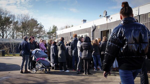 Украинские беженцы стоят в очереди за материальной помощью в Доккедале, Дания