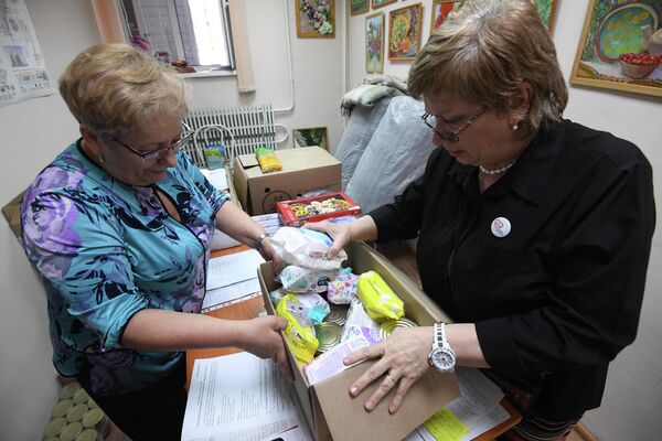 Женщины сортируют принятую у населения гуманитарную помощь для беженцев с юго-востока Украины в центре общественных объединений Советского района Новосибирска