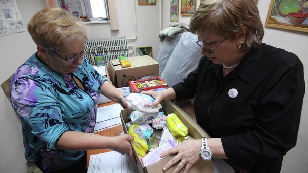 Женщины сортируют принятую у населения гуманитарную помощь для беженцев с юго-востока Украины в центре общественных объединений Советского района Новосибирска