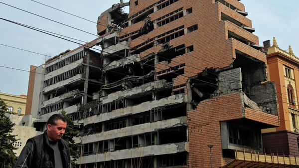 Мужчина проходит мимо здания бывшего федерального военного штаба в Белграде, разрушенного во время воздушной кампании НАТО. 24 марта 2010 года
