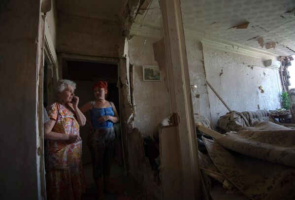 Местные жители в своей квартире, пострадавшей во время артллерийского обстрела Краматорска.