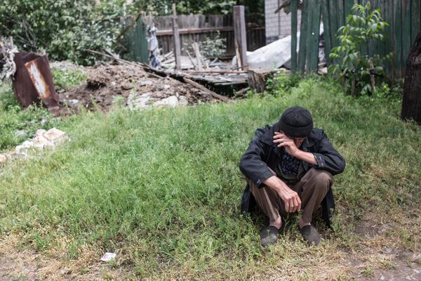Пожилой мужчина возле своего дома, разрушенного в результате попадания снаряда во время обстрела украинскими силовиками, в поселке Червоный Молочар возле Славянска