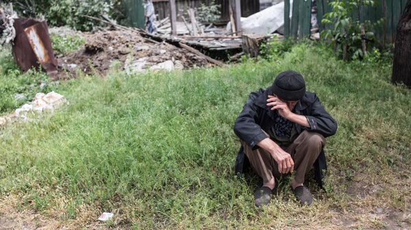 Пожилой мужчина возле своего дома, разрушенного в результате попадания снаряда во время обстрела украинскими силовиками, в поселке Червоный Молочар возле Славянска