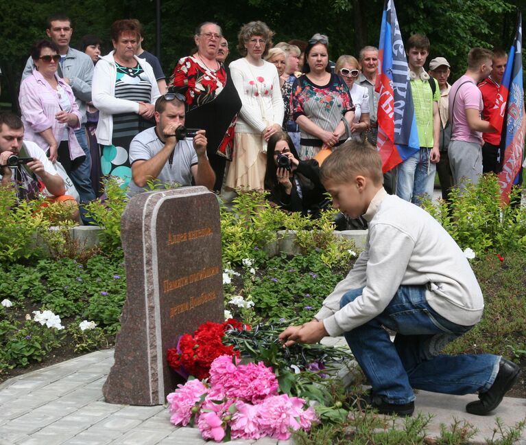 Юный житель Донецка возлагает цветы к мемориалу Ангелы Донбасса