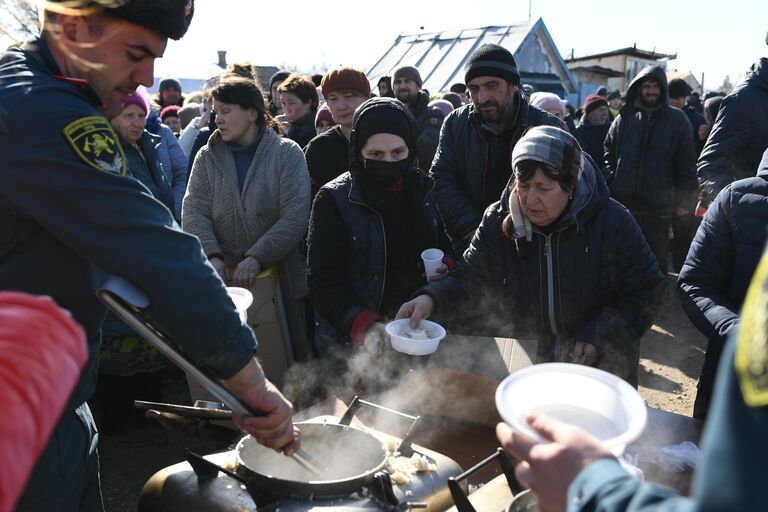 Беженцы из Мариуполя в очереди за горячей едой в пункте временного размещения, организованном МЧС ДНР в селе Безыменное