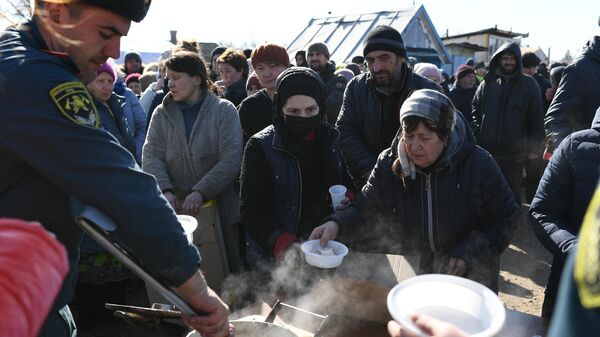 Беженцы из Мариуполя в очереди за горячей едой в пункте временного размещения, организованном МЧС ДНР в селе Безыменное