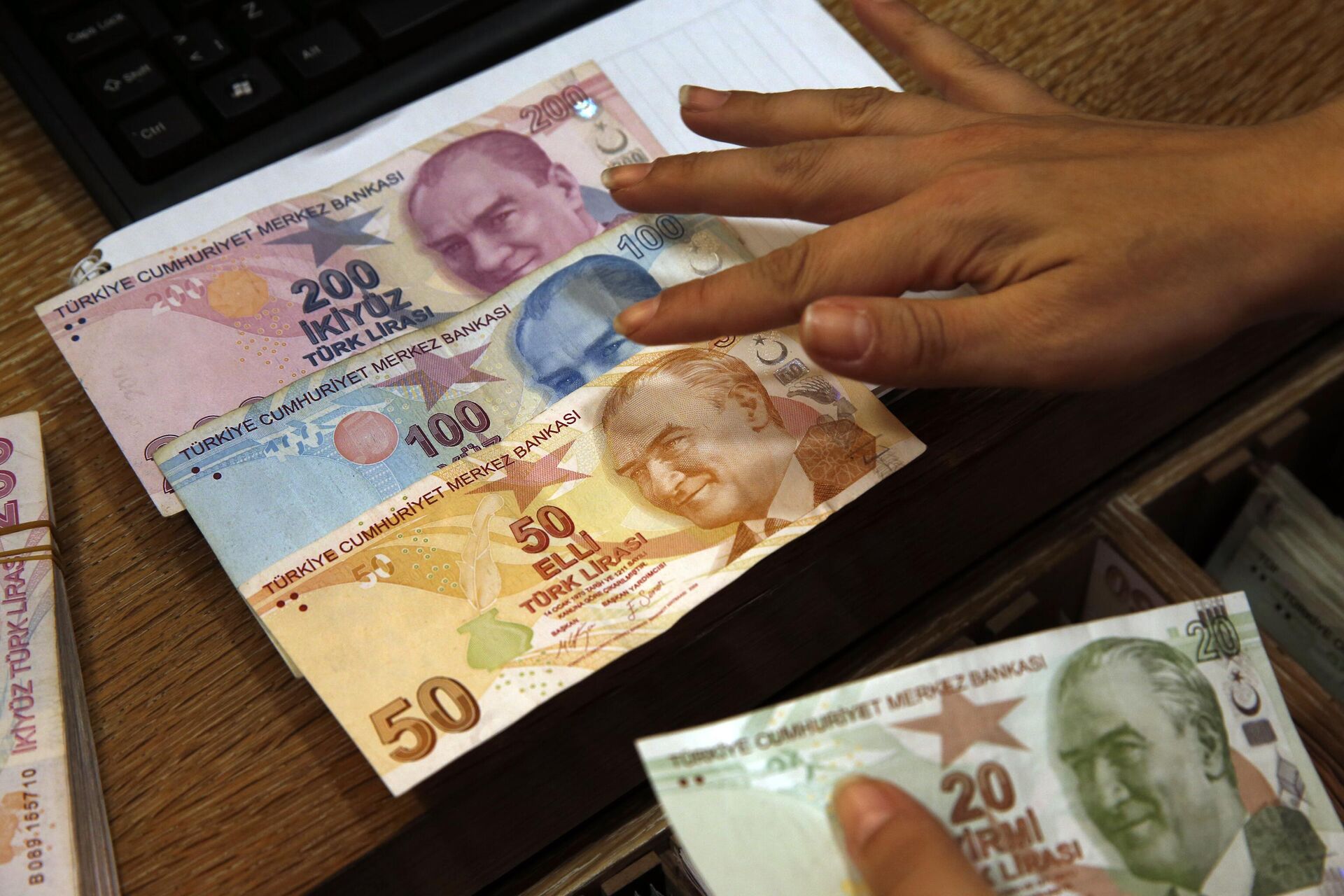 Работник пункта обмена валюты демонстрирует банкноты в турецких лирах - РИА Новости, 1920, 25.03.2022