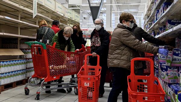 Покупатели приобретают товары первой необходимости в супермаркете в Мадриде 
