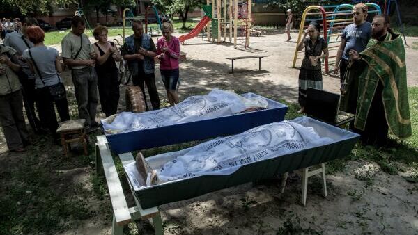 Отпевание погибших во дворе жилого дома. Последствия артиллерийского обстрела украинскими военными микрорайона Артема в Славянске.