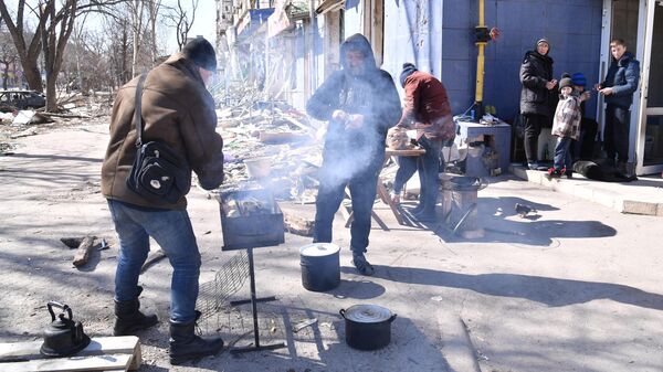 Жители готовят пищу на одной из улиц Мариуполя