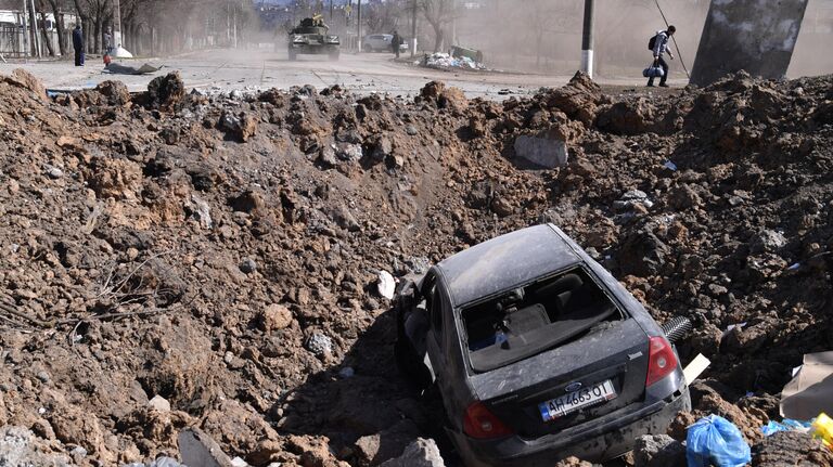 Автомобиль в воронке на улице Мариуполя