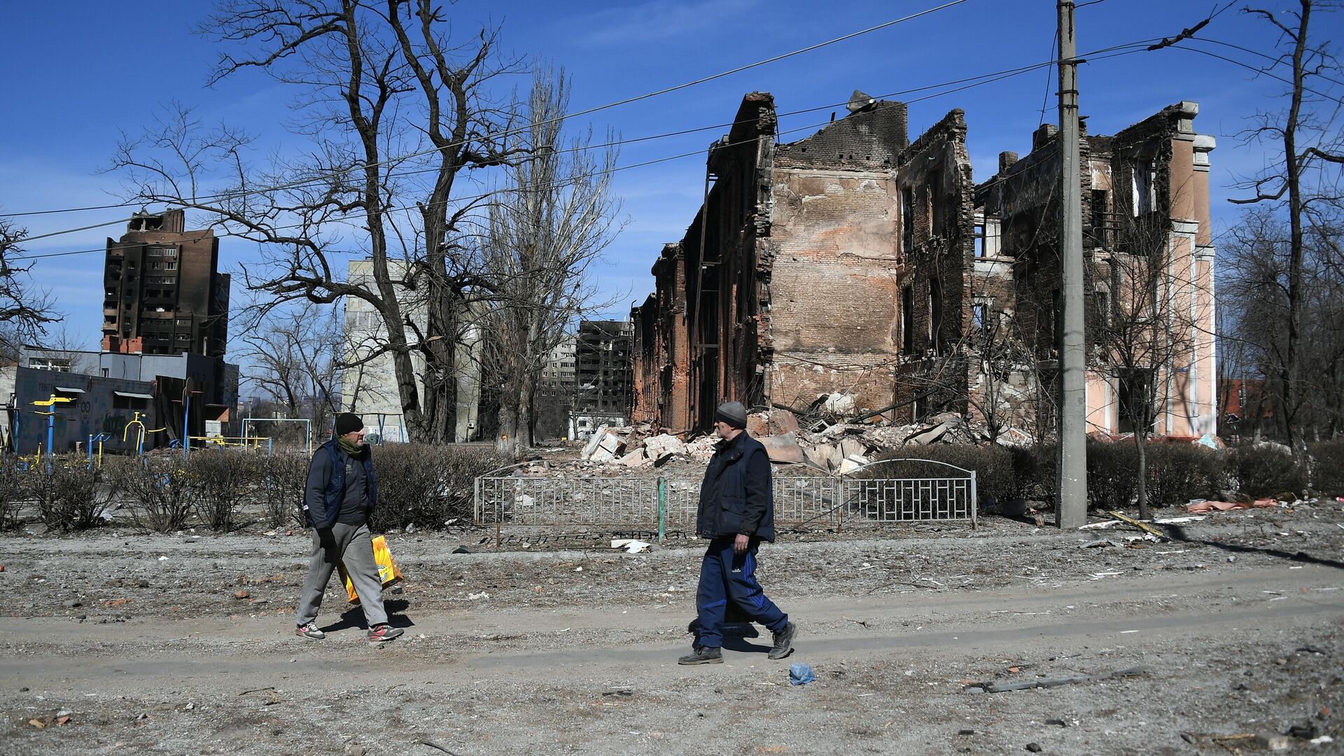 Жители города у разрушенного в результате обстрелов жилого дома в Мариуполе - РИА Новости, 1920, 30.03.2022
