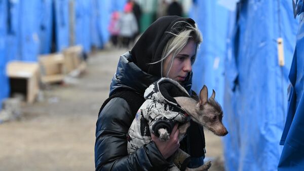 Девушка с собачкой в пункте временного размещения беженцев из Мариуполя, организованном МЧС ДНР в селе Безыменное
