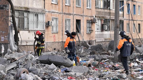 Сотрудники МЧС ДНР ликвидируют последствия попадания снаряда ВСУ в жилой дом в Донецке