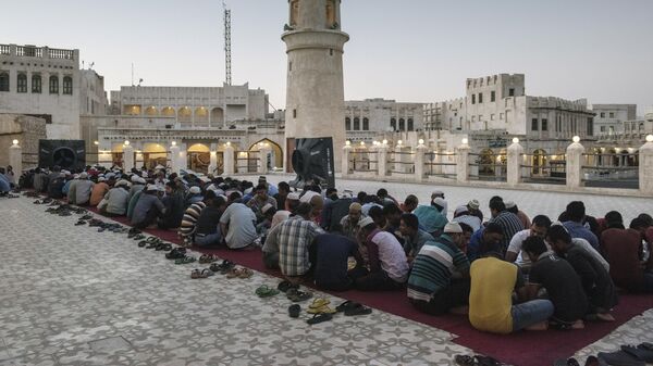 Мужчины на вечернем приеме пищи во время месяца Рамадан в одной из мечетей города Доха