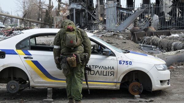 Военнослужащий Народной милиции ДНР у разобранной машины украинской полиции в Мариуполе