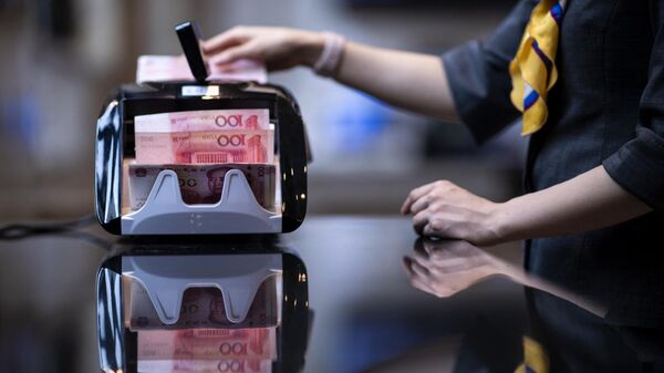Банковский служащий пересчитывает юани 