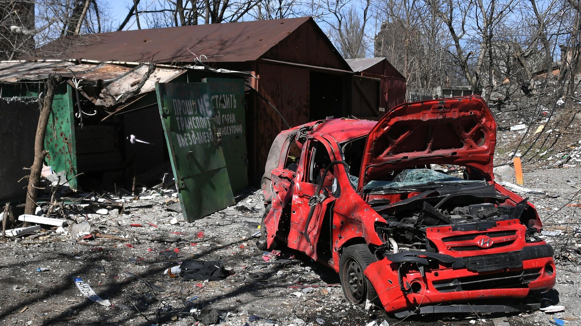 Уничтоженный автомобиль во дворе разрушенного в результате обстрелов жилого дома в Мариуполе - РИА Новости, 1920, 06.04.2022