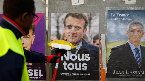 Работник наклеивает официальный предвыборный плакат президента Франции и кандидата на переизбрание Эммануэля Макрона в Сент-Эрблен 