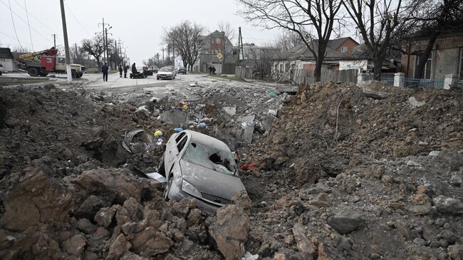 Автомобиль в воронке от взрыва в Мариуполе