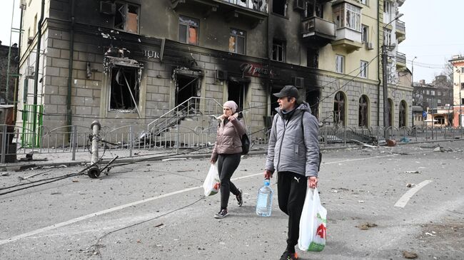 Жители города во дворе разрушенного жилого дома в Мариуполе