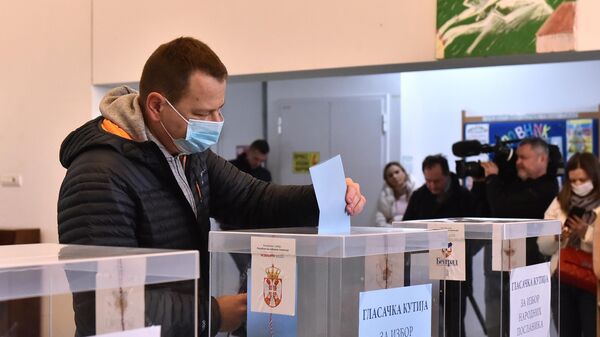 Мужчина принимает участие в парламентских и президентских выборах на одном из избирательных участков в Белграде
