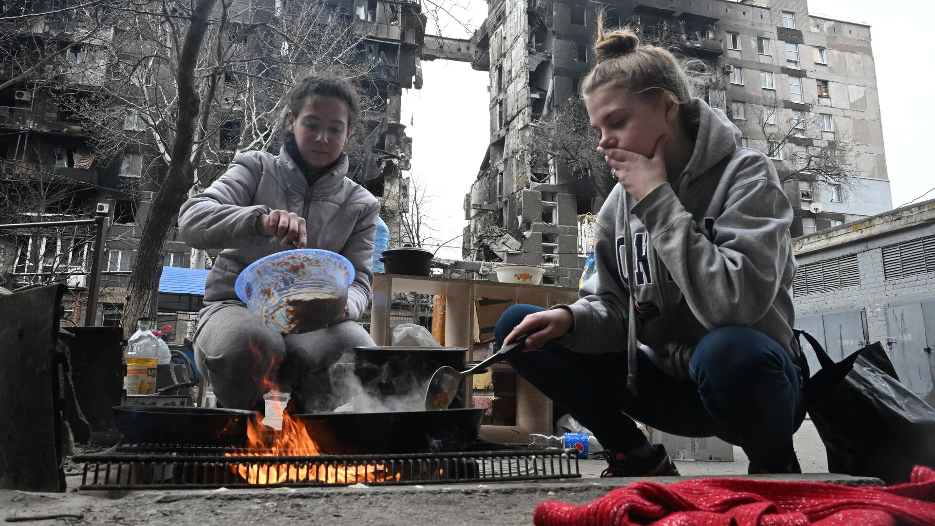Жители Мариуполя готовят еду во дворе разрушенного дома - РИА Новости, 1920, 04.04.2022