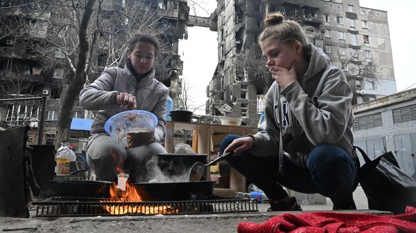 Жители Мариуполя готовят еду во дворе разрушенного дома