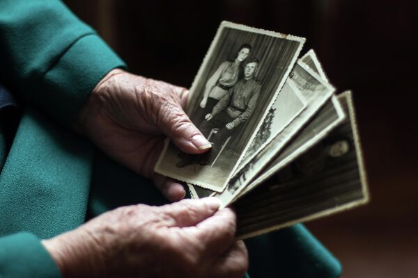 Ветеран Великой Отечественной войны, радистка, участница взятия Берлина Мария Попова смотрит фотографии у себя дома в Донецке.